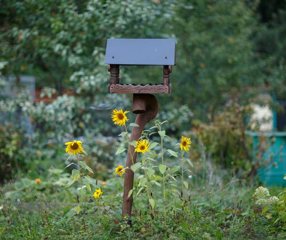 A rustic bird feeder surrounded by blooming sunflowers in a vibrant garden
